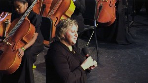 Orchestra teacher, Ms. Anne Tschetter, addresses the audience at the Penn spring orchestra concert in the Penn CPA. Ms. Tschetter was awarded the 2017 PHM Teacher of the Year. (Image courtesy of Lucha Ramey, PHM-ESC)